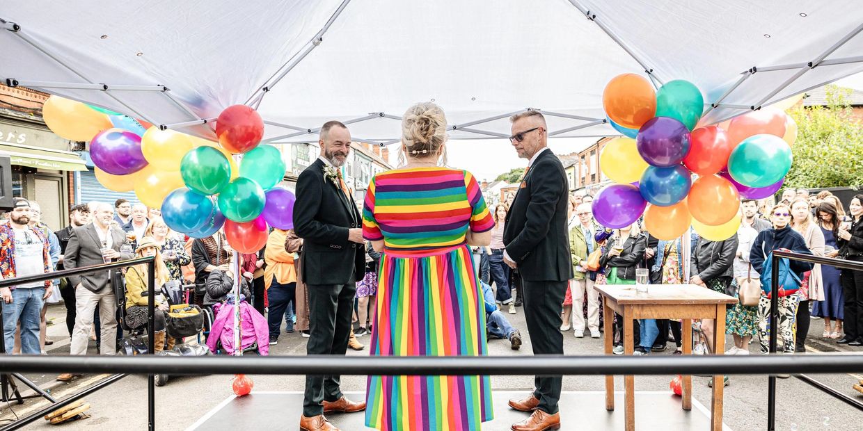 A gay couple celebrating their wedding with a celebrant