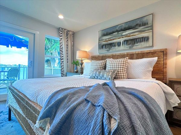 Cozy bedroom with a large bed and balcony view.
