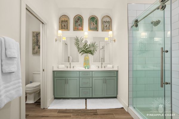 Elegant bathroom with green vanity and glass shower.
