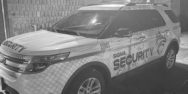 Security vehicle parked by a brick wall.