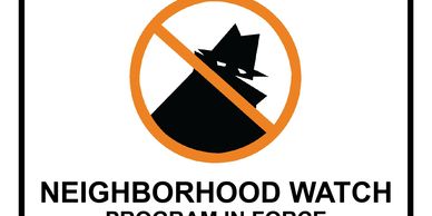 Neighborhood watch warning sign alerting to report suspicious activities.
