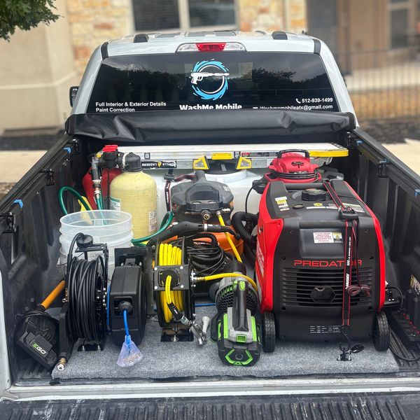 Truck bed loaded with professional cleaning equipment.