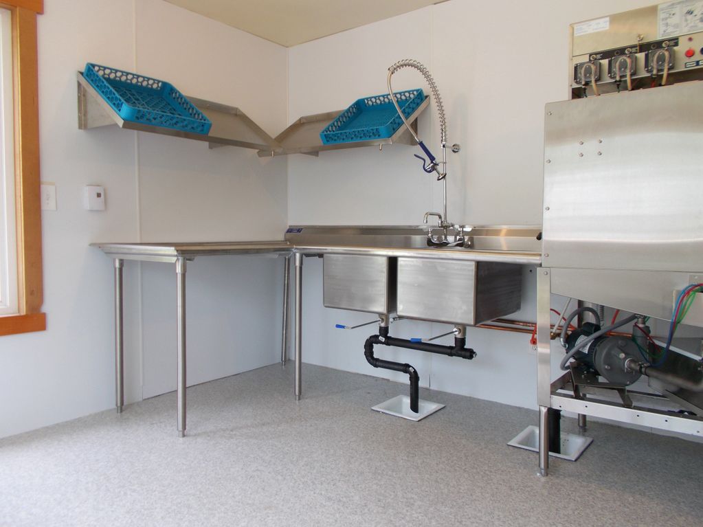 Commercial kitchen setup project at Doe Bay Resort, Olga WA: dishwasher, shelves, table, and sink