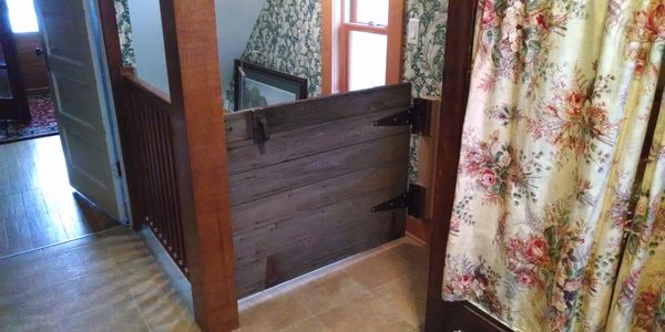 Repurpose this old barn door for custom gate at top of the stairs. 