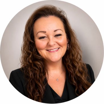 Smiling woman with curly hair in black attire.