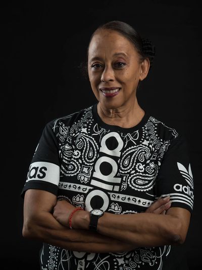 Mujer sonriente con camiseta Adidas negra con estampado blanco.