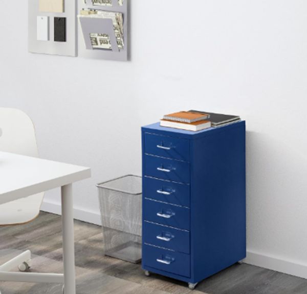 Blue six-drawer storage unit with notebooks on top.