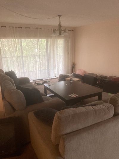 Cozy living room with large sofas and a coffee table near a bright window.