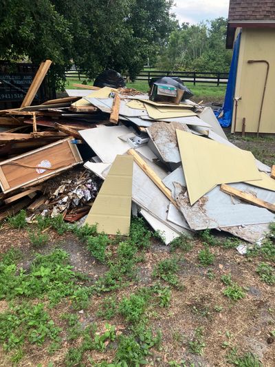 Pile of discarded wooden and drywall pieces outdoors.