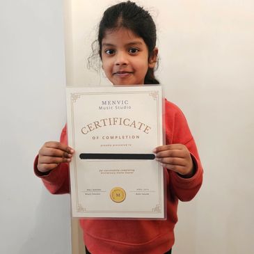 Young girl proudly holding a music certificate of completion.