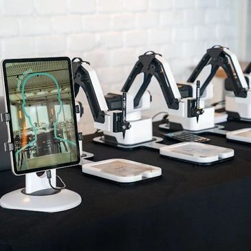 Digital sketching robots are set up at the event, ready for guests to interact