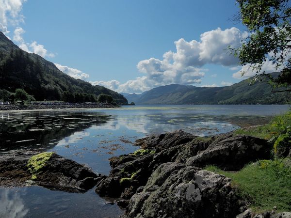 Scenic lake with surrounding mountains and rocks.