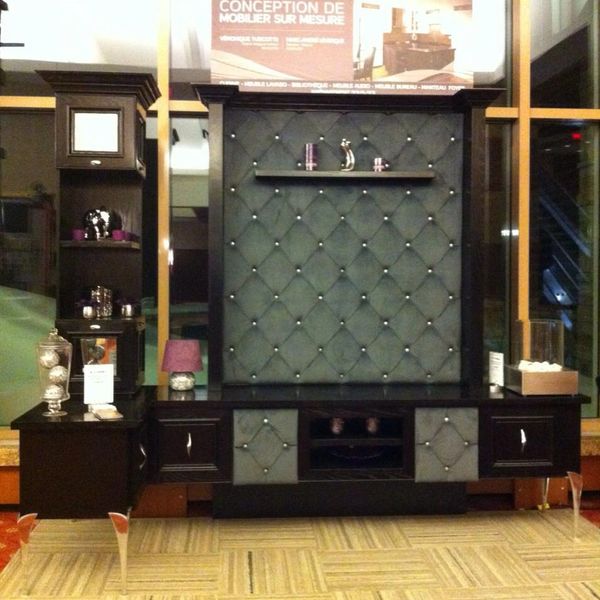 Elegant dark wood entertainment unit with tufted back panel and silver accents.