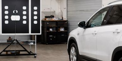 A white car undergoing a crash test in a testing facility.
