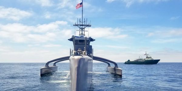 Front view of a high-tech naval vessel with an American flag at sea.