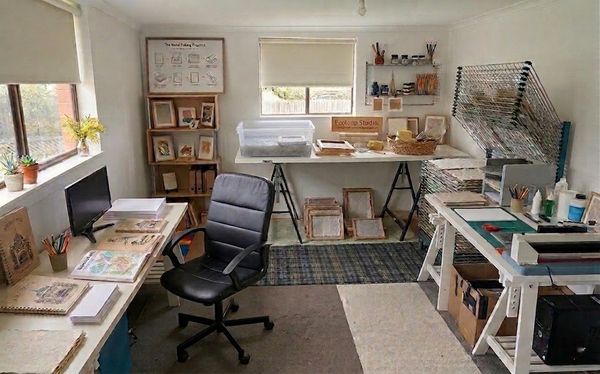 A well-organized art studio with worktables and drying racks.