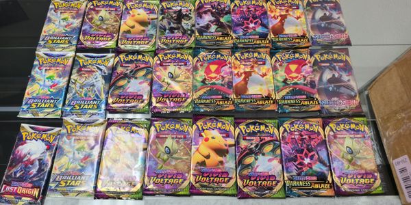 display of sealed pokemon booster packs from different sets