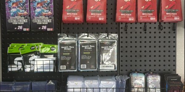 Display of One Piece trading card sleeves and accessories on a pegboard wall.