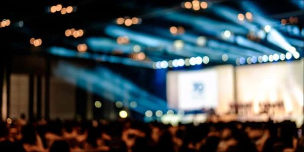 Blurred image of a crowded event with stage lights.
