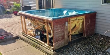 Outdoor hot tub with exposed inner insulation and components.