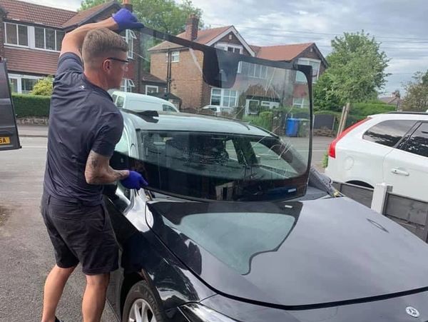 Special auto worker replacing the windshield or windshield of a car 