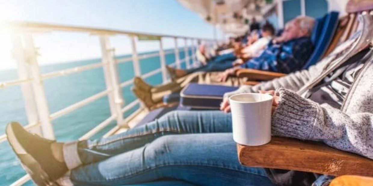 People relaxing on a ship deck with drinks.