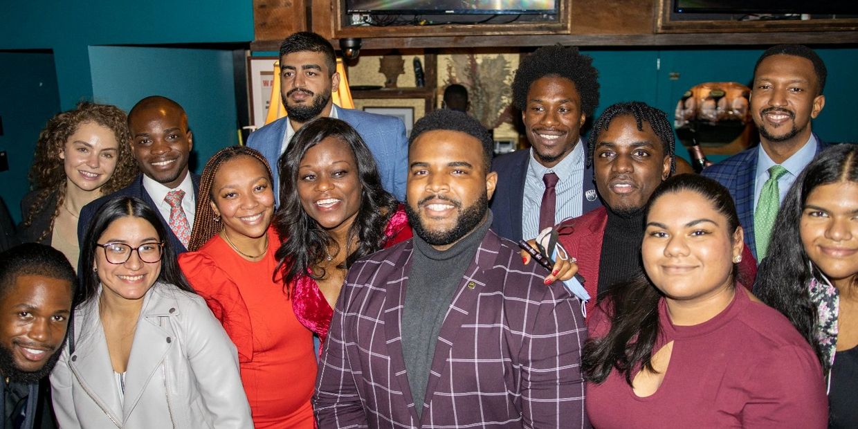 A diverse group smiling together indoors.