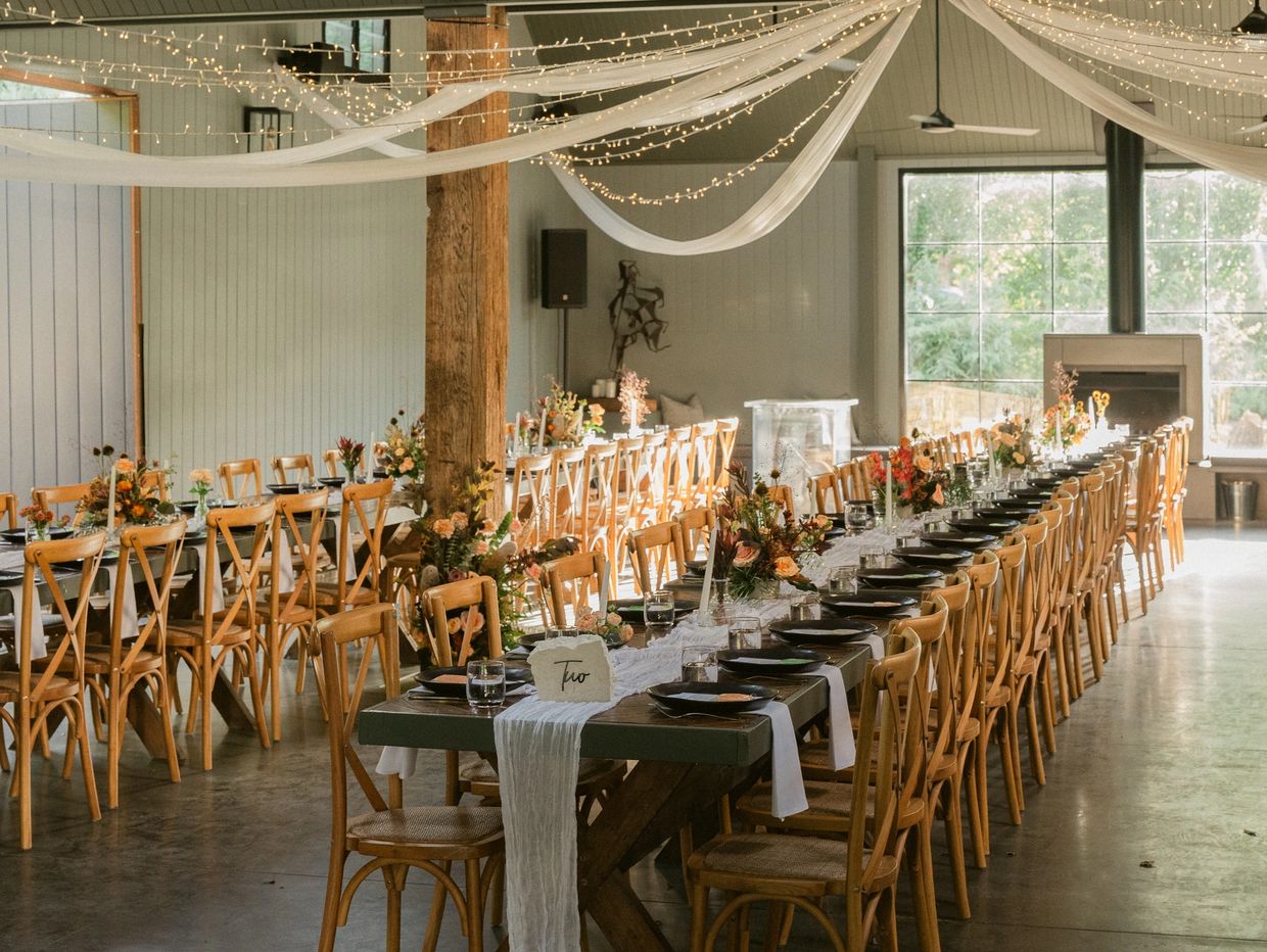 Long reception tables all setup with drapes hanging from the ceiling