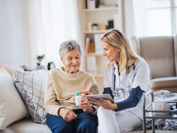 A nurse explaining to an elderly woman how to take her medicine