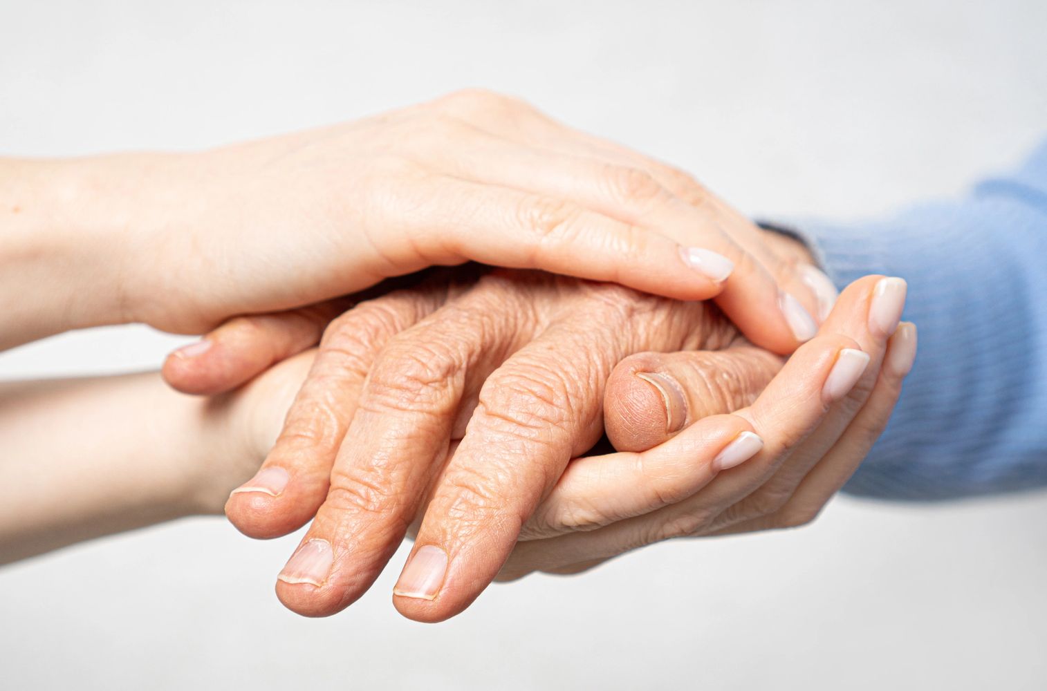 A carer holding an old person's hand