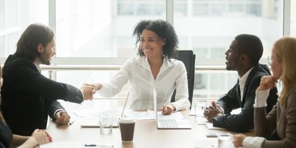 Business meeting with handshake and smiles.