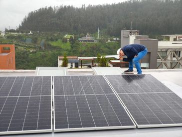 Persona revisando paneles solares en el techo.