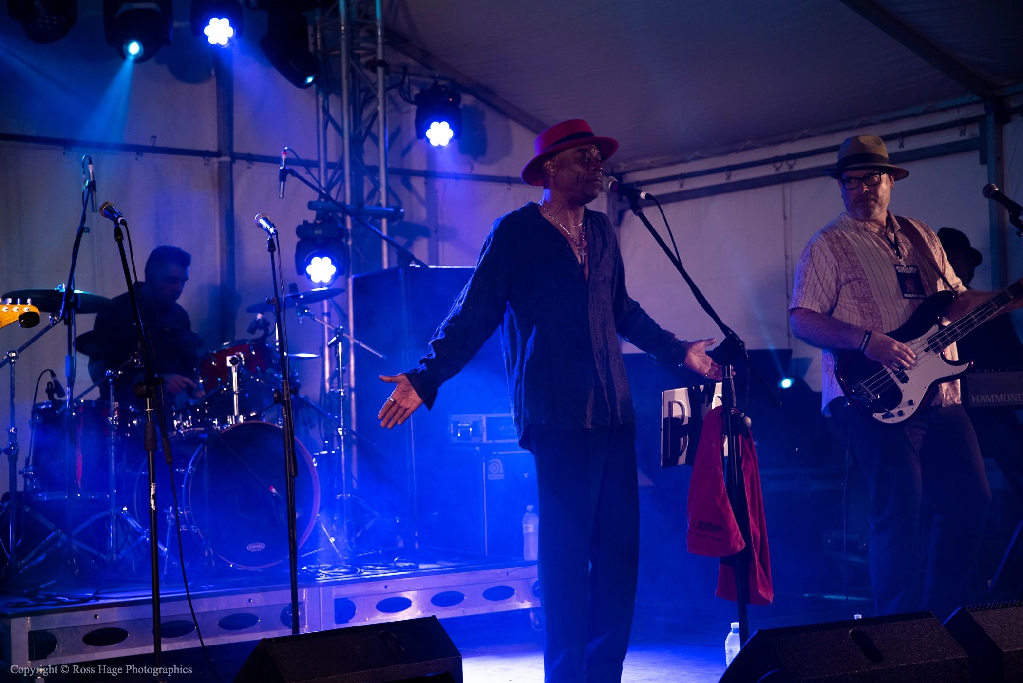 Band performing live on stage with vibrant blue lighting.