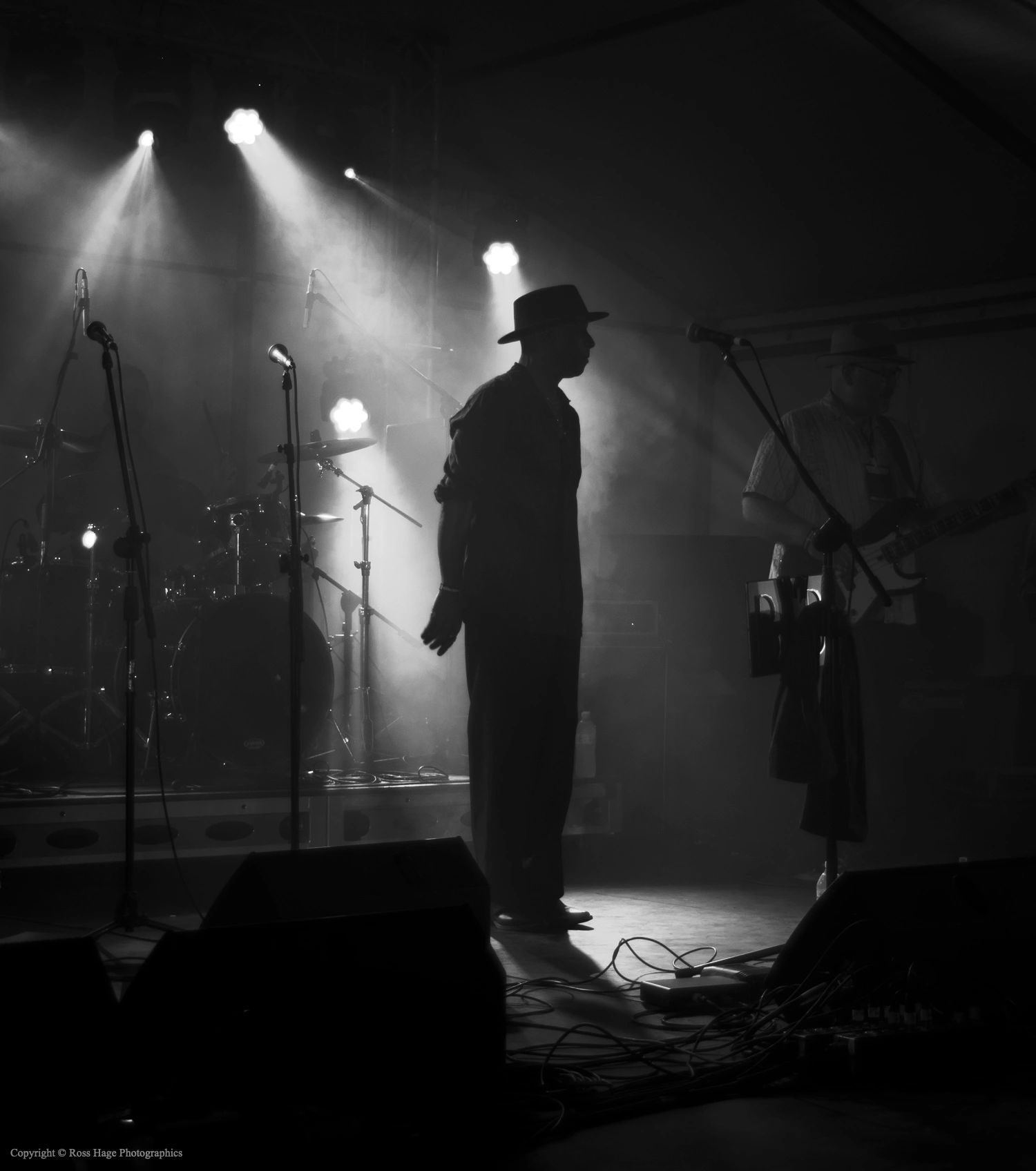 Silhouetted musicians performing on stage with dramatic lighting and smoke effects.
