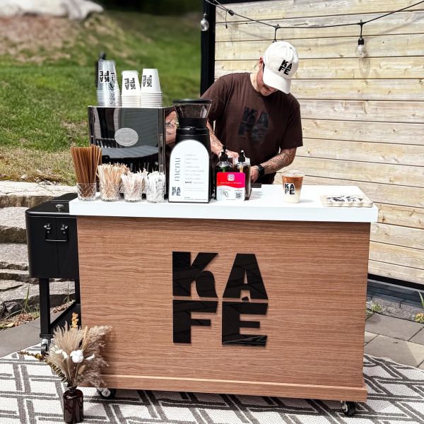 Barista préparant du café à un stand moderne en bois.