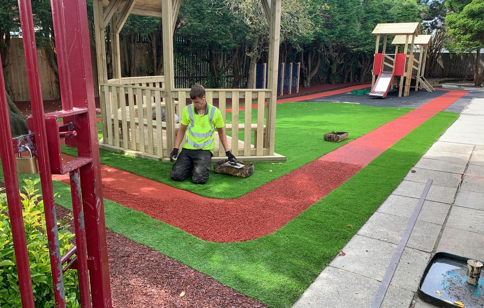 Primary Play UK staff at work installing wetpour playground surface with additional equipment