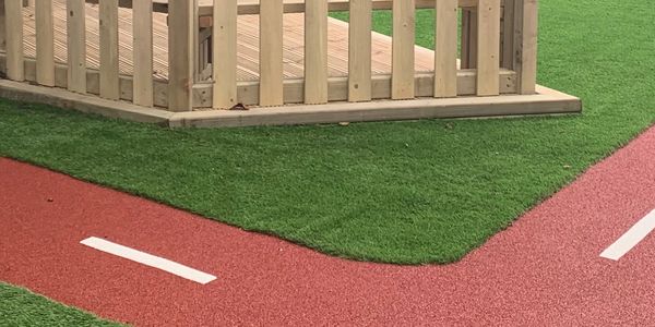 Artificial grass with running track installation for children's playground area