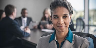 Confident businesswoman in a meeting room with colleagues.