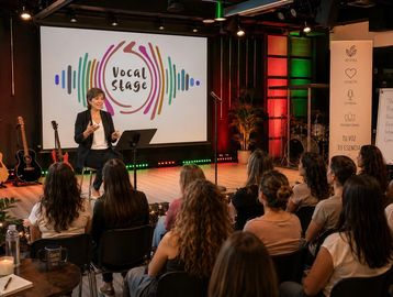 Speaker presenting at a Vocal Stage event to an engaged audience.