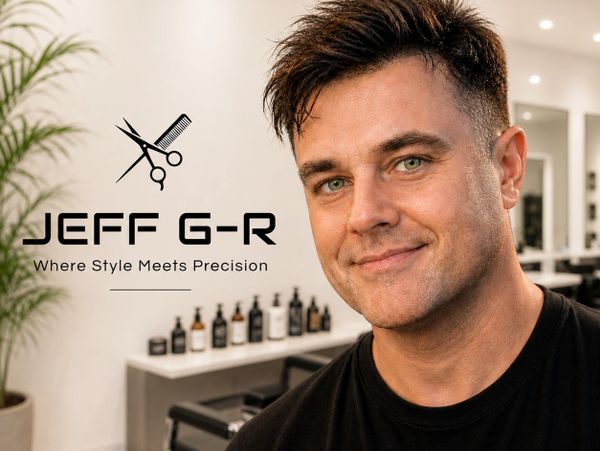 A man smiling in a stylish barbershop with the logo 'JEFF G-R, Where Style Meets Precision'.