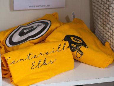 gold spirit wear shirts on a shelf