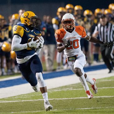 Two football players from opposing teams in action on the field during a game.