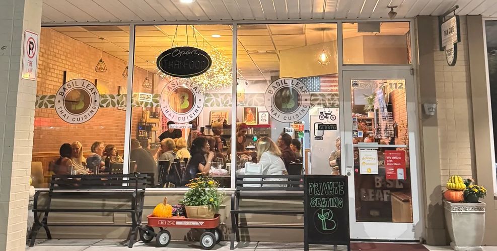 Stack of books next to pencils in a holder and a camera.