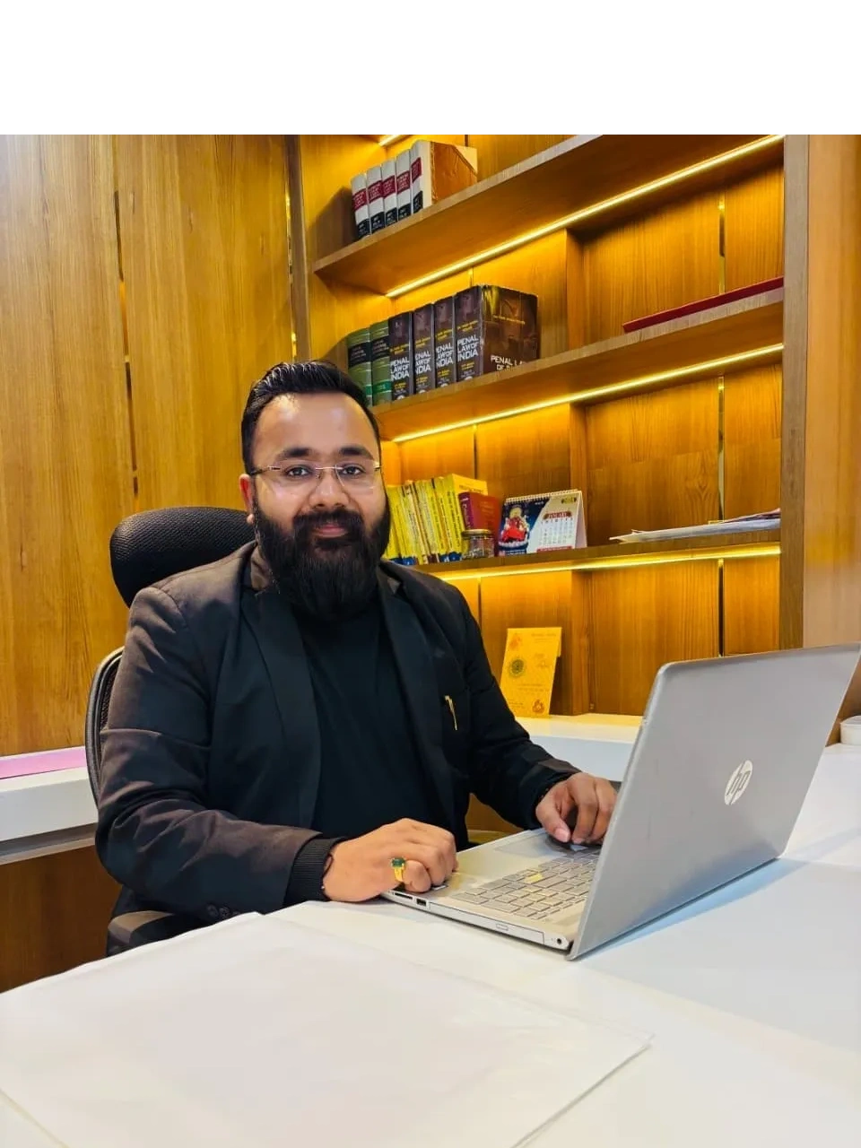 Advocate Harshit Goyal working on a laptop in his office.
