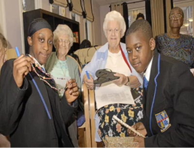 Young and elderly people crafting together indoors.