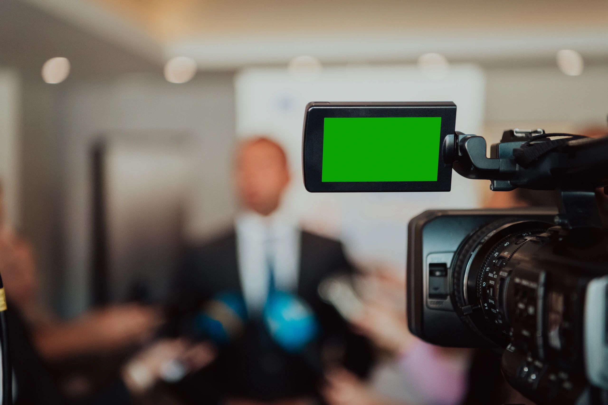 Television camera focuses on public speaker during media interview for television and radio