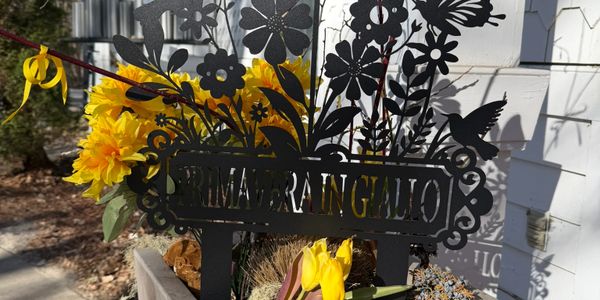 Decorative black metal garden sign with floral and hummingbird design.