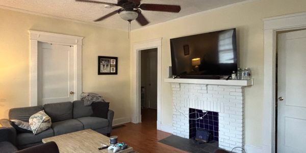 Cozy living room with TV above white fireplace.