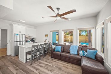 Open game room living space with kitchenette and bar seating at Serenity Cove