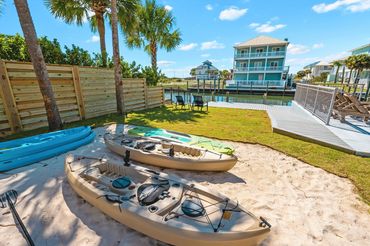 Beach kayaks stored on sand court area for guest use at Serenity Cove Perdido Key